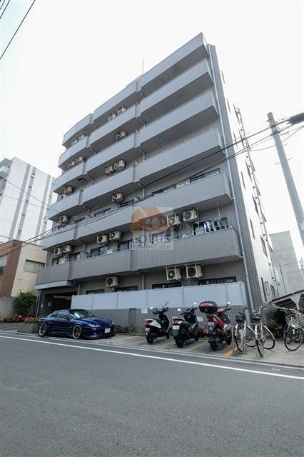 三の輪シティハウスの外観全景。前面道路に面した7階建のシンプルな外観で、道路沿いにはバイク置場・自転車置場・駐車スペースも設けられており、利便性に配慮された造り。三の輪シティハウスは平成３年築の９階建てのマンションです。「三ノ輪」駅より徒歩７分の住宅街にあります。近くには「一葉記念館」があります。