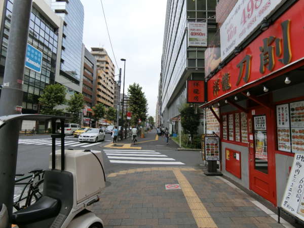 新宿第２アルプスマンションアプローチ（東新宿）4｜大久保エリアはマンションとオフィスビル、商店が立ち並ぶエリアです。この辺りは徒歩１～２分くらいで、明治通りの反対側です。写真の左にある交差点をわたれば新宿第２アルプスマンションです。