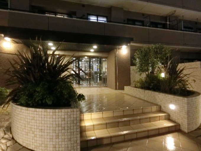 コスモ葛西臨海公園ロイヤルコート外観共用部1｜夜間のエントランスの様子です。植栽と門灯で設えられた外観です。