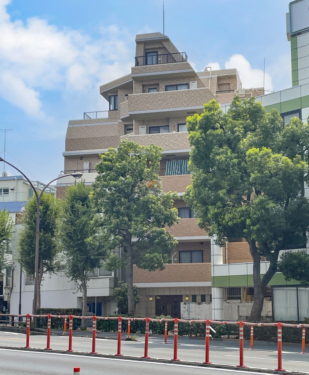 外壁はベージュ系のタイルで統一され、直線的なフォルムが印象的です。環七通り沿いという立地ながら、植栽や歩道の緩衝帯があり、都市景観の中に柔らかさを感じます。レクシオシティ高円寺は平成16年築、7階建てのマンションです。