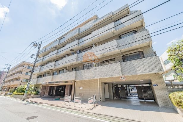 タック練馬北町の外観で、タイル貼りの落ち着いたデザインと6階建の水平ラインが整った外観です。道路に面した明るい立地で、堅実な印象を与える中規模マンションです。タック練馬北町は、平成元年築、6階建てのマンションです。