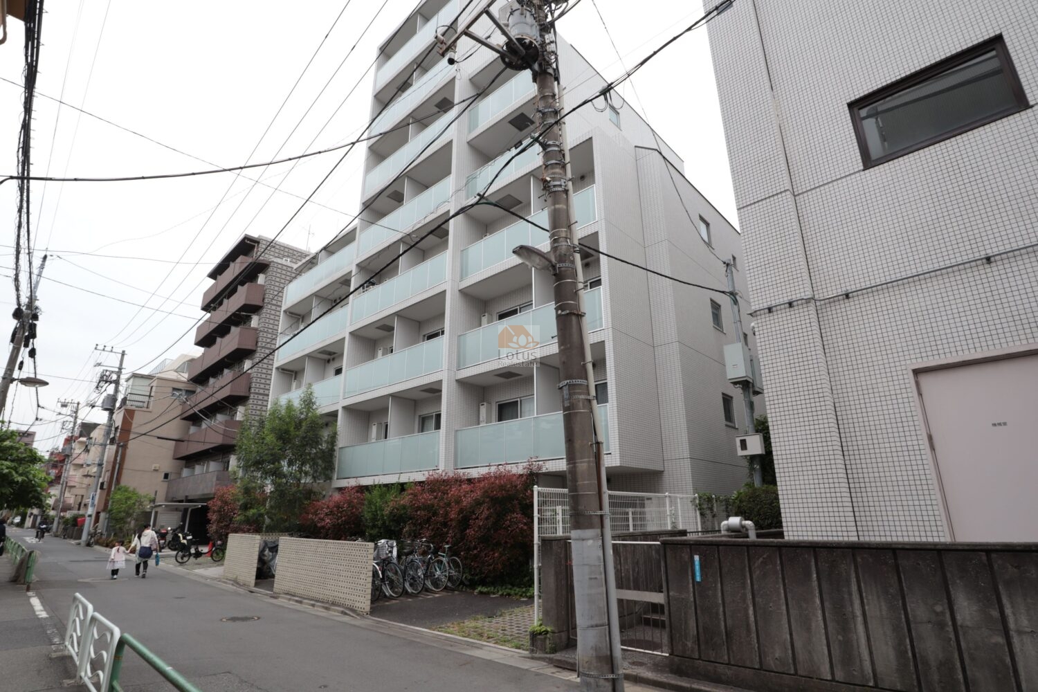 レガリス門前仲町パークサイドの外観は、白系タイルとガラス手すりが重なり合う中規模マンションの構成です。通り沿いに建ちつつも、建物足元に植栽帯を設け、歩行者との距離を緩やかに保っています。清澄白河・門前仲町エリアらしい住宅街のスケール感に収まる外観といえます。