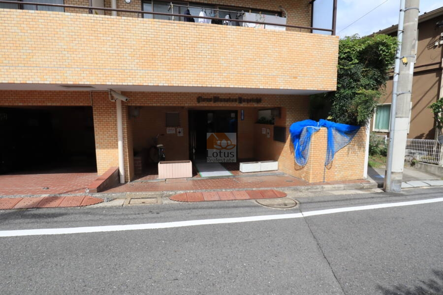 ライオンズマンション弥生町エントランス2｜エントランスはスロープ状に１段下がったところにあります。網はゴミ出しのためのもので、管理人さんが出してくれるそうです。