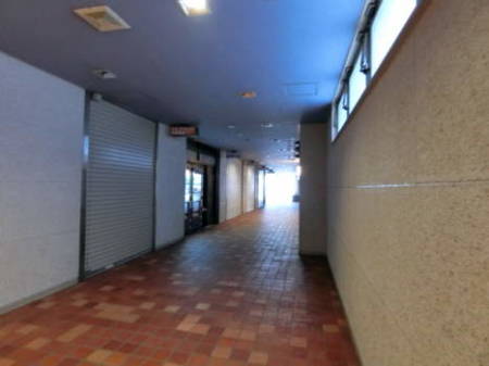 飯田橋ハイタウン 共用部4｜エントランスを入って奥まで進んで、中から道路側を見た構図です。店舗が出店しています。写真の日は休日でしたのでしまっています。