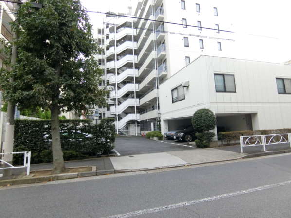 菊川パークホームズ外観・共用部11｜駐車場は建物の裏側にあります。右手の小ぶりな建物は集会場です。