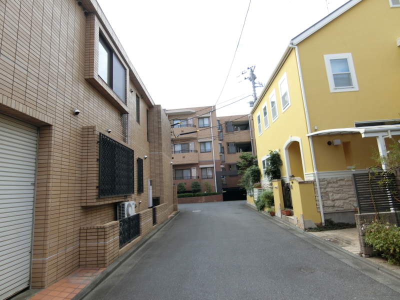 ファミールグラン目白外観共用部4｜西側の公道からの佇まいです。ベースラインは濃いめのブラウンのタイルとなっています。周辺の落ちついた街並みの雰囲気に調和させた外観です。