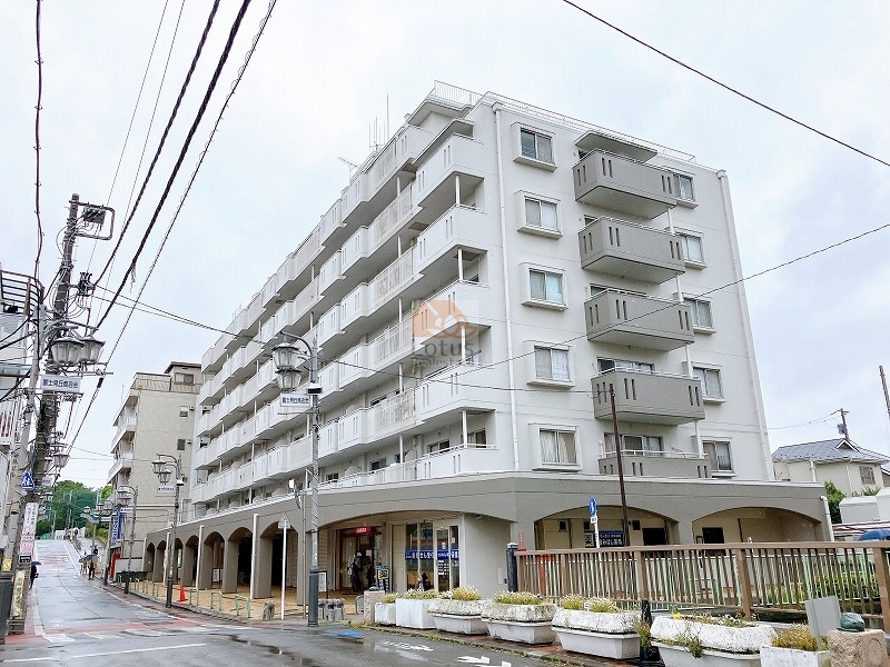ハイネス富士見ヶ丘の外観。アーケード付き1階店舗と白を基調としたシンプルな外観が、駅前の利便と住宅の落ち着きを両立させています。ハイネス富士見ヶ丘は昭和52年築、8階建てのマンションです。