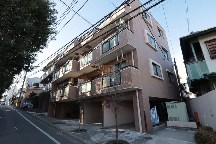 セザール第３鷺ノ宮外観1｜総レンガタイル貼りの外観が、穏やかな住宅街にしっくりと馴染んでいます。バルコニーのガラス手すりと白フレームが、外観に軽やかさを添えています。空を背景に、端正なシルエットが映えます。