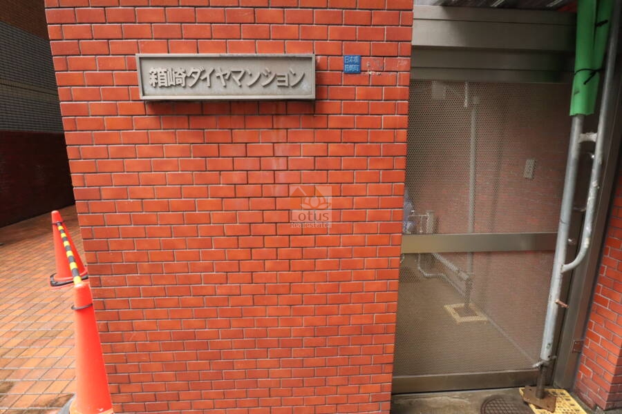 箱崎ダイヤマンションエントランス2｜館銘板のよこにゴミ集積場がありました。