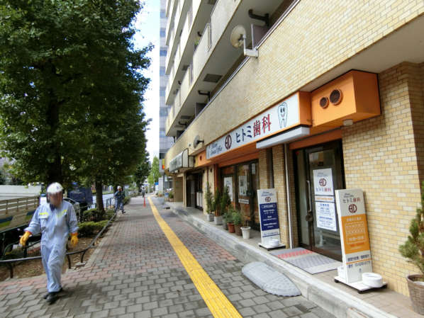 朝日関口マンションアプローチ3｜駅からこのような広めの歩道を歩いて３分ですから、すぐ到着しました。１階部分は歯科・飲食店が入っているマンションです。