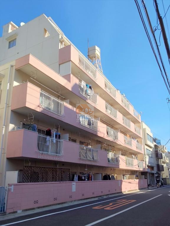 白とアースピンクの外観が特徴で、南向きバルコニーが並ぶ配置です。東西線「早稲田」駅まで徒歩7分の距離感で、日中は光をしっかり受ける側に居室が並ぶつくりになっています。3駅3路線利用可という条件を踏まえると、落ち着いた路地に面している点は少し意外に感じます。