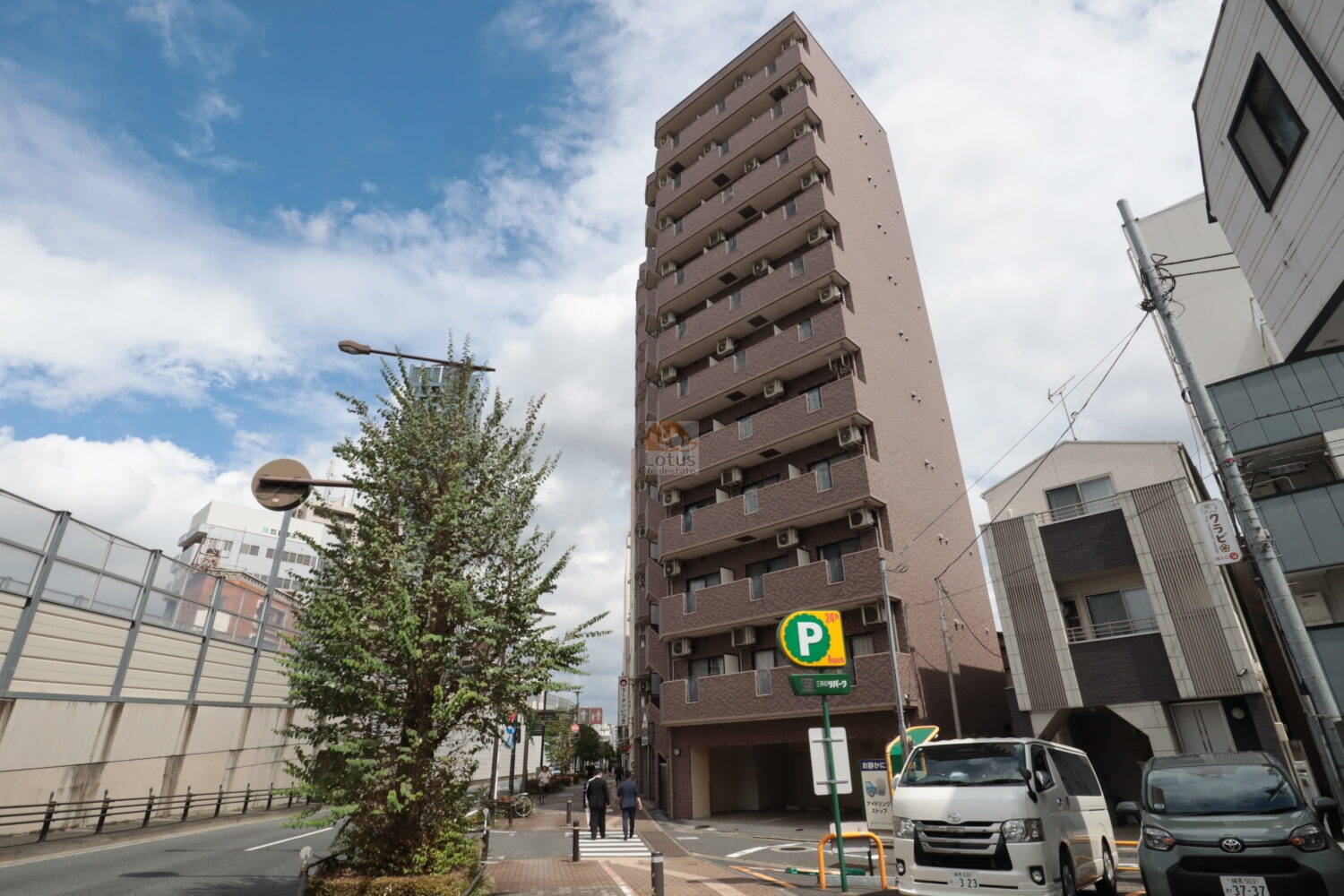 表通りのアプローチから望む外観。スリムに伸びる建物が青空に映えています。駅に近い立地でありながら、ひとなつっこさを感じる一角にあることを思わせる景観です。