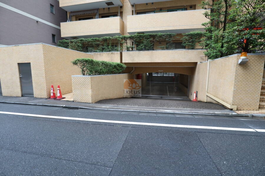 ライオンズマンション箱崎町共用部1｜エントランスの左脇に駐車場のスロープがあります。駐車場は半地下に設置されています。