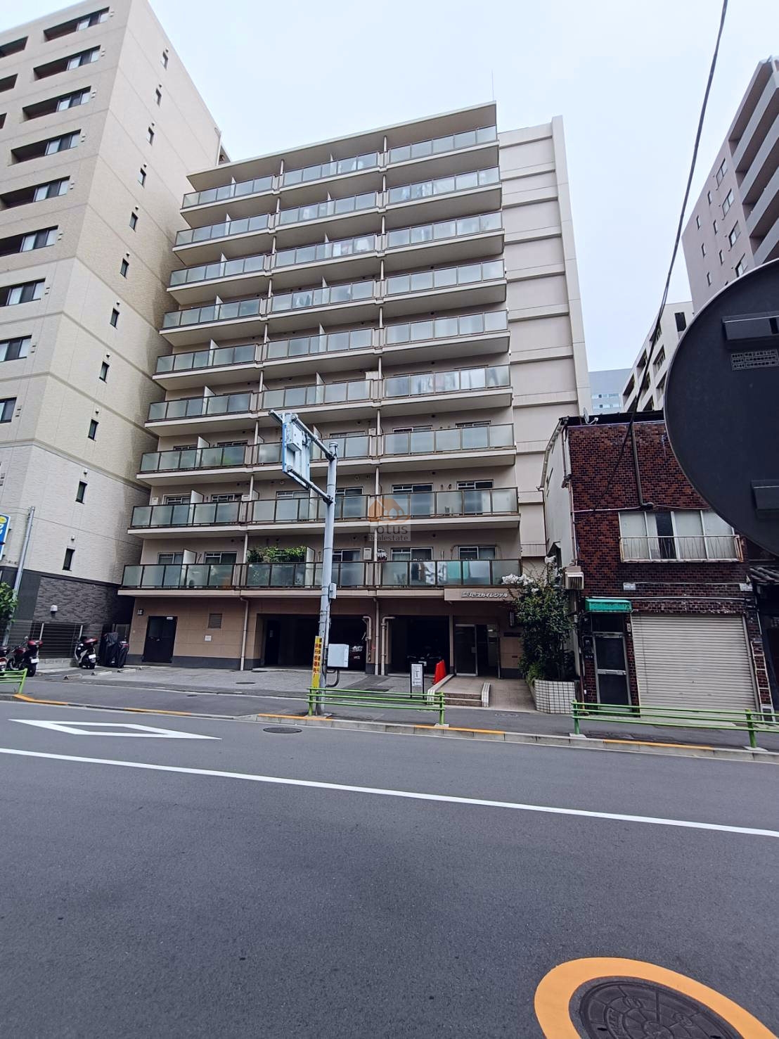 築地スカイレジテルの外観（正面ファサード）。静かな通り沿いに建ち、全戸がバルコニー付きで開放感のある構成となっている。周囲には築古の戸建ても混在し、都心ながらも下町らしさが残る界隈です。築地スカイレジテルは、昭和５５年築、１０階建てのマンションです。
