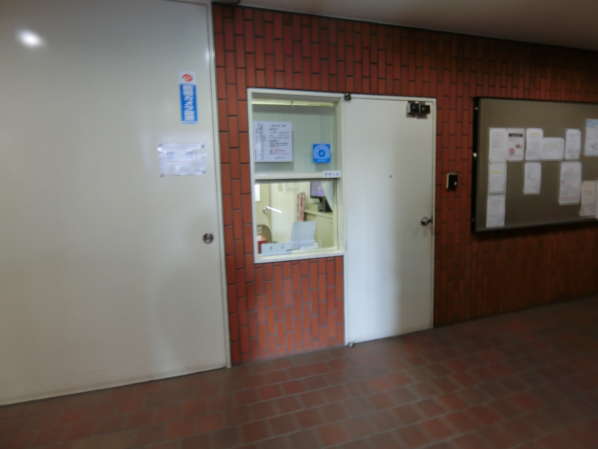 クリエート三田外観・共用部7｜エントランスに入ると階段を少し降りる格好になります。管理人さんの控えスペースがあります。耐震診断済みのシールがあります。