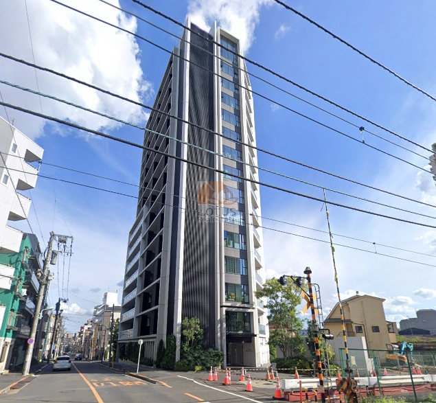 シティハウス東池袋の外観。街並みにそびえる地上15階建て、白いタイルと縦のルーバーが織りなすモノトーンの構成で、周囲の低層住宅と鮮やかなコントラストを描いていました。幹線道路から少し奥まった立地で、西側には都電荒川線の線路があり、建物の足元には植栽が整えられ、都市の中に静かな緑の境界線が存在しているのを実感しました。シティハウス東池袋は、平成28年築、15階建てのマンションです。