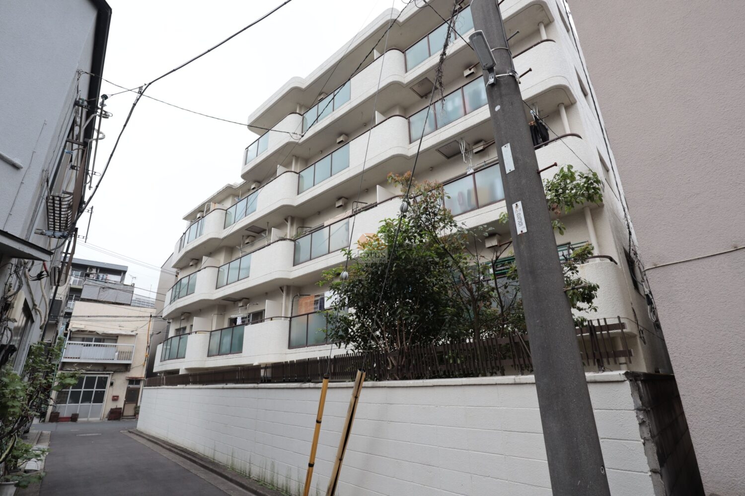 秀和門前仲町レジデンスの外観という位置づけです。白系の外壁と連続するバルコニーが通りに対して穏やかな輪郭をつくり、下町の住宅街に自然に溶け込んでいます。低層寄りの高さで空が広く感じられ、日常の距離感が落ち着いて伝わる佇まいです。