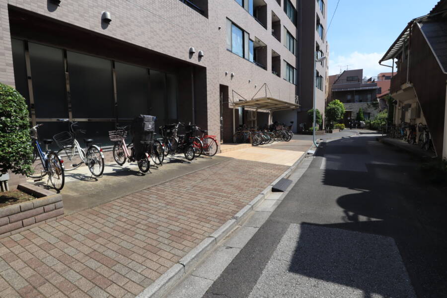 ヴェルビュ堀切菖蒲園共用部7｜建物の裏側は公開空地、駐輪場となっていて、サブエントランスも設置されています。