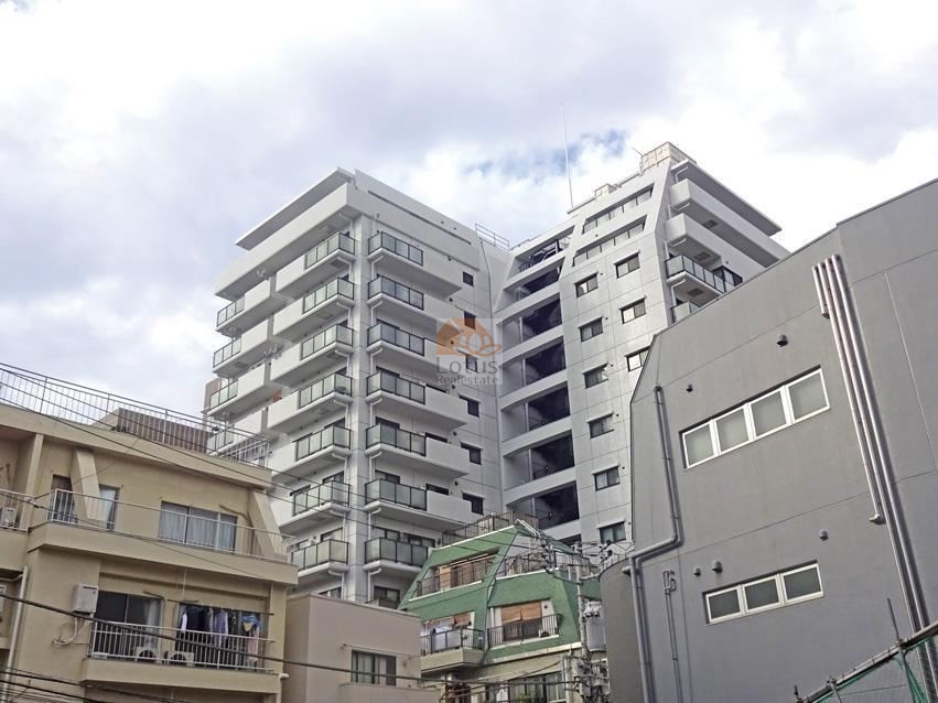 南側から見ると白タイルの質感が均整に整えられ、光のあたり方で陰影が落ち着いて見えます。中層〜高層の住戸が連続するラインが読み取りやすく、総戸数125戸の大規模マンションとしてのまとまりがあります。曙橋駅徒歩1分という立地が日常動線の効率を高め、都心へのアクセスと生活利便性を兼ね備えたエリアに相応しい外観構成といえます。