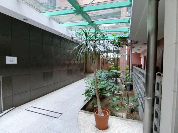 コスモ西大島ロイヤルフォルム外観共用部3｜エレベータへと向かう回廊は明るいサンルーム風となっています。