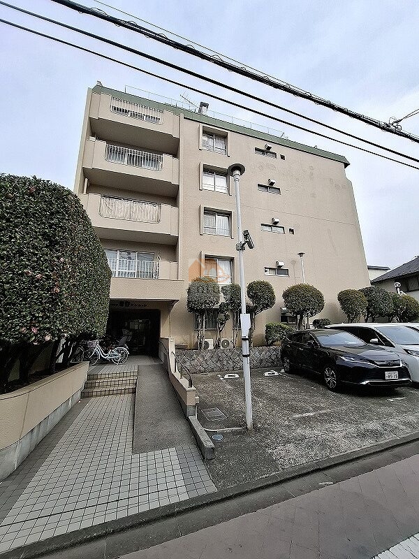 パシフィック目白マンション外観。街路に面して並ぶ駐車場と整えられた植栽、その奥に7階建ての外観がみえます。初めて目にしたとき、落ち着いた住宅専用地域の雰囲気が漂い、池袋駅徒歩圏にありながら静かな住環境が息づいていることを実感しました。パシフィック目白マンションは、昭和46年築、7階建てのマンションです。