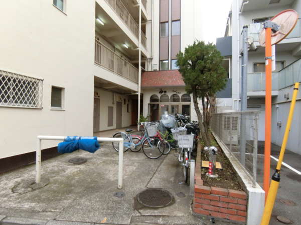 中野ニューハイム外観共用部3｜自転車置き場と兼ねたエントランスアプローチです。庶民的な印象を受けるマンションでした。