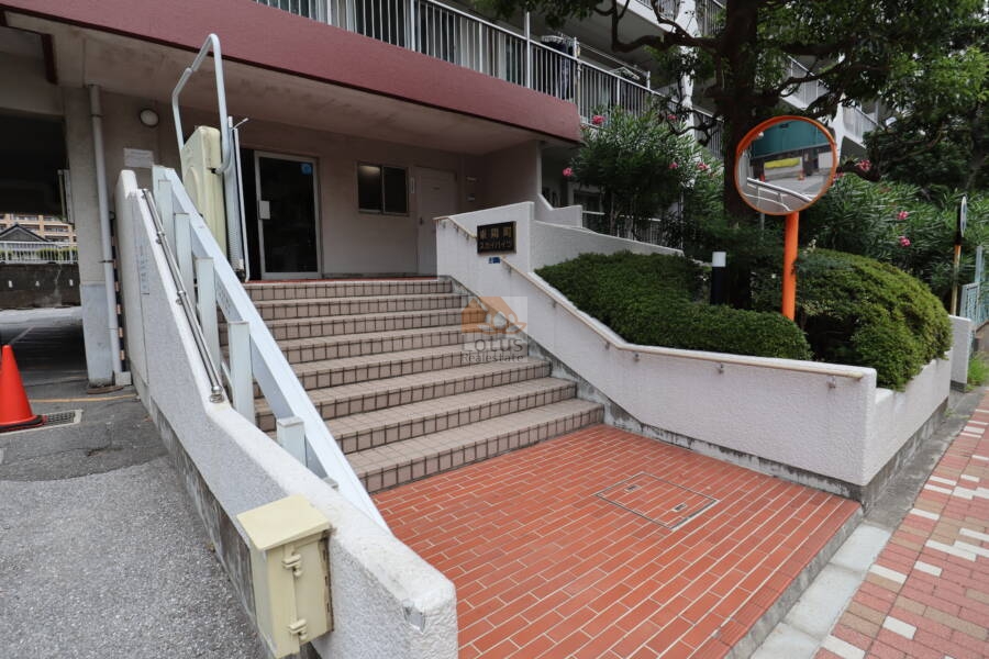 東陽町スカイハイツエントランス1｜エントランス階段には建物銘板が設置され、階段の横にはスロープが備えられています。