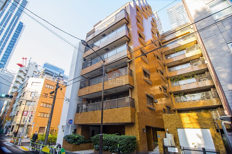 虎ノ門ガーデン外観はレンガ調のタイル貼りで、道路に面した角地に建ち、周囲はオフィスビルや中高層の建物が立ち並んでいます。低層部分には植栽が設けられ、建物の足元を緑が囲んでいます。虎ノ門ガーデンは昭和５７年築、１０階建てのマンションです。