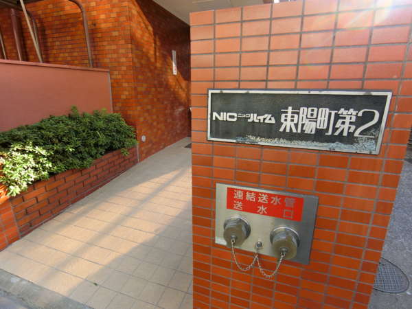 ニックハイム東陽町第２外観共用部4｜エントランスの館銘板もいい味を出してます。この写真の左手にごみ置き場スペースがあります。