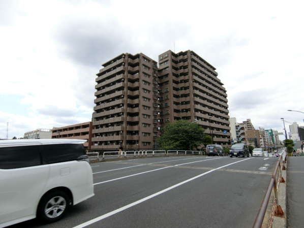 ライオンズプラザ西大島外観・共用部1｜同じく橋の向かいから見た外観で、少し引いてみました。通りと川に面した開放的な空間だと思います。