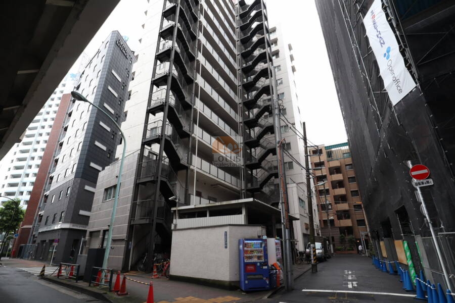 日本橋箱崎ハイツ外観3｜裏手側です。金属製の外階段と縦長の共用廊下が視認でき、機能性を重視した造りが特徴です。敷地内には自販機と駐輪スペースも備わり、日常の利便性も考えられています。