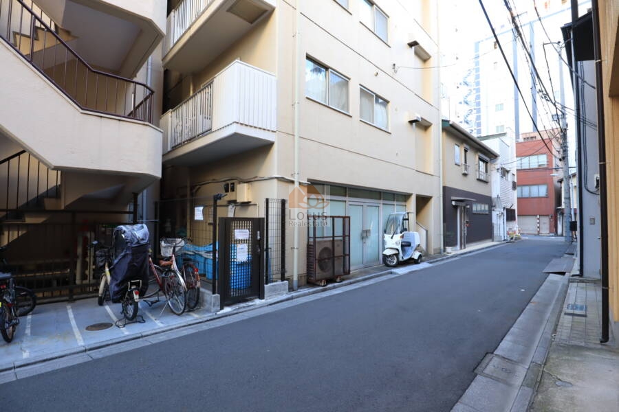 コンコード仲御徒町共用部2｜建物裏手には駐輪場やゴミ置き場が設置され、生活インフラが整った印象です。周囲は住宅と店舗が混在し、生活感のある下町の空気が流れています。