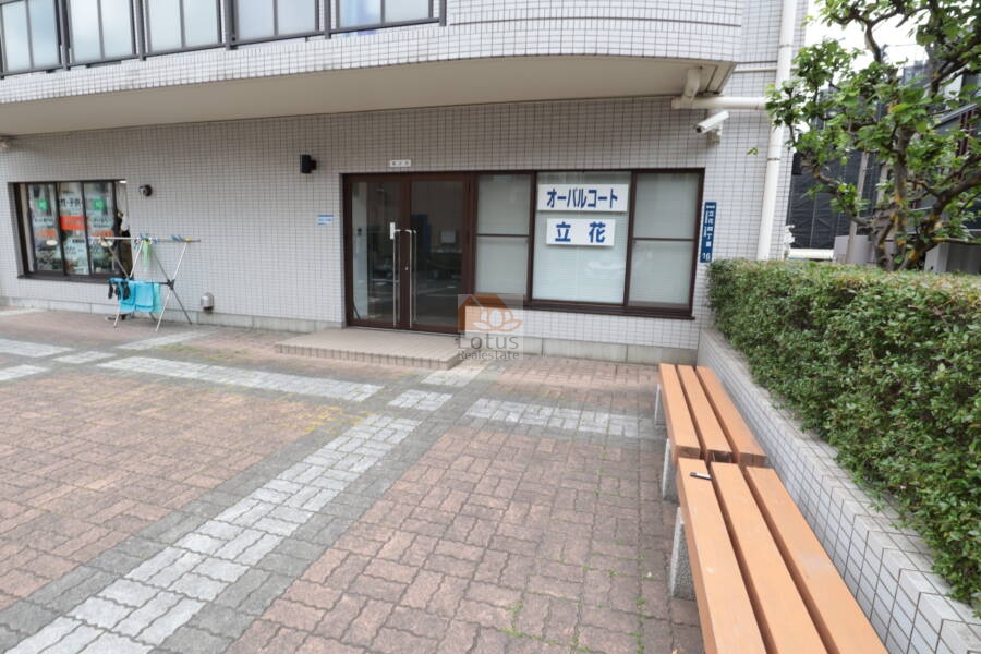オーバルコート立花共用部2｜集合室前の共用空間。植栽に沿ってベンチが設置されており、来訪者の待機やちょっとした休憩に便利です。