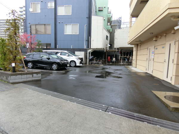 ヴェレーナ木場公園外観共用部9｜駐輪場と駐車場はエントランスに向かって左側に配置されています。物件の北側です。直接道路に面していて見通しは良好。