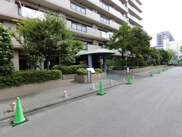 ライオンズガーデン錦糸町外観共用部3｜エントランスは西向の棟に配置されています。道幅も広く、建物の間口も広く、堂々とした印象です。歩道との間に植栽を設け、アプローチ空間にゆとりを確保。開放感のあるファサードが印象的です。