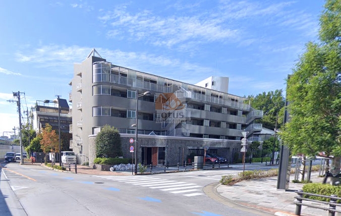 ロイヤルパレス大崎の外観。角地に立つ建物は、整ったファサードと開放感あるバルコニーが並ぶデザイン。前面道路は広く歩道も整備され、暮らしやすい住環境。ロイヤルパレス大崎は、平成7年築、5階建てのマンションです。