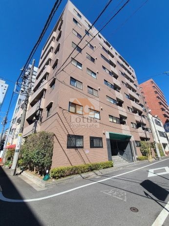 マイキャッスル水天宮前壱番館外観４｜マイキャッスル水天宮前壱番館の建物外観。茶系タイル張りの外壁で、8階建の角地に位置する建物が写っています。周囲には電線や街路樹も確認できます。