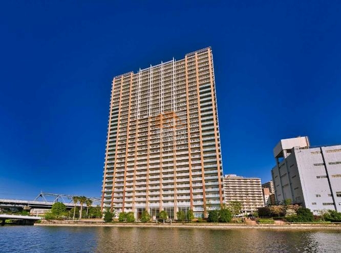 高浜運河に面して伸びる32階建ての塔姿が、水辺と都市を結ぶ構図です。空を映す立面が距離感を穏やかに整えます。