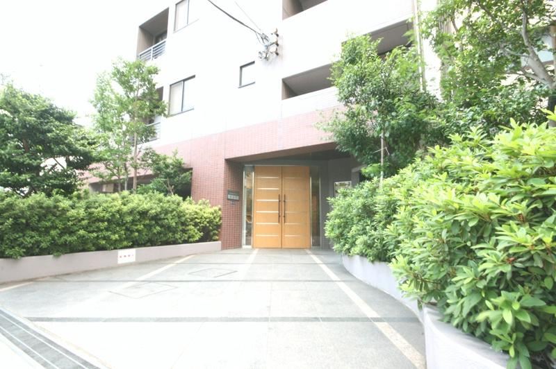 レクセルマンション錦糸町5｜エントランスは、両側に緑の植栽があり、平坦で広々としており、車いすやベビーカーの利用者にも配慮された設計になっています。