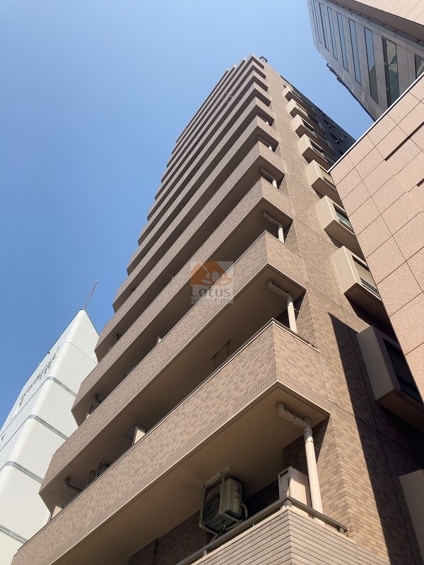 春日通り沿いに立つ地上14階建の外観です。後楽園駅徒歩7分の距離感にあり、バルコニーの奥行きが通りとの間に穏やかな陰影をつくります。