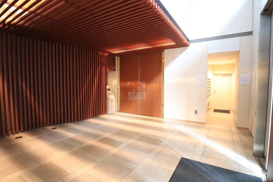 アスコットパーク新御徒町ソレイユ共用部1｜エントランス内部は木製ルーバーが目を引く上品な空間です。