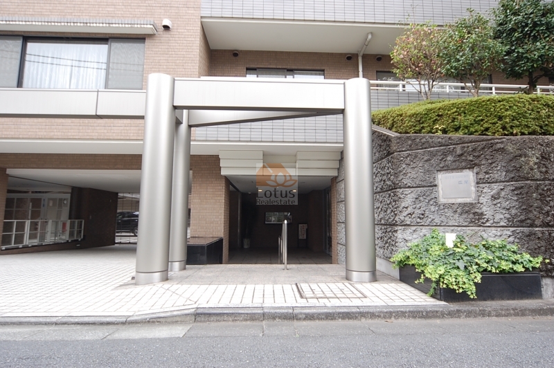 シティコート広尾2｜中央のゲートは駐車場入口になっています。敷地内の植栽に大きな木が植えられています。