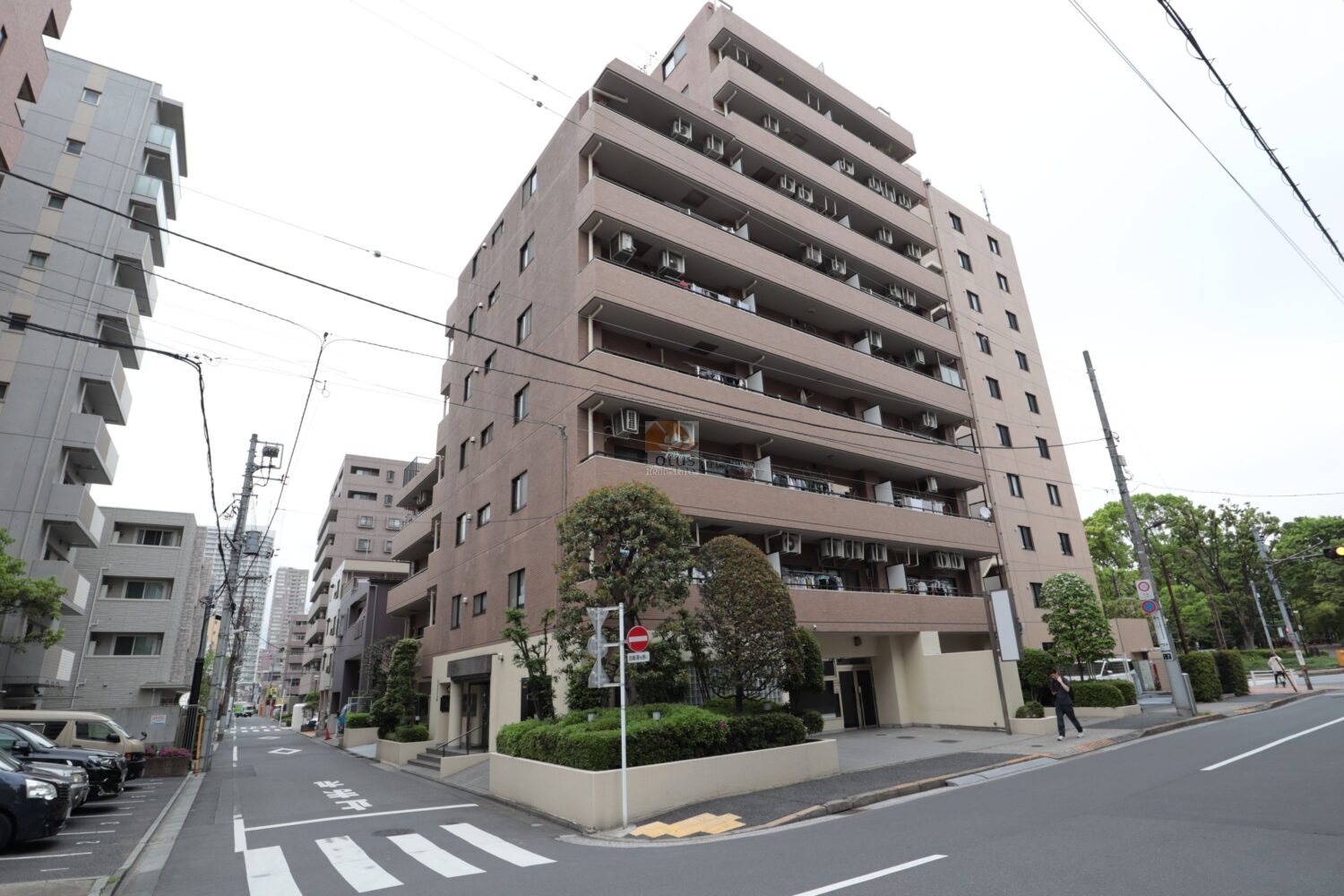 藤和シティコープ木場公園の外観は、タイル張りの外壁と直線的なバルコニー構成が確認できる中規模マンションです。角地に近い位置関係で、歩道と車道の分離がはっきりしており、視界が抜けた印象。周囲に高木と街路樹が点在し、下町エリアながら落ち着いた距離感で建物が立っています。