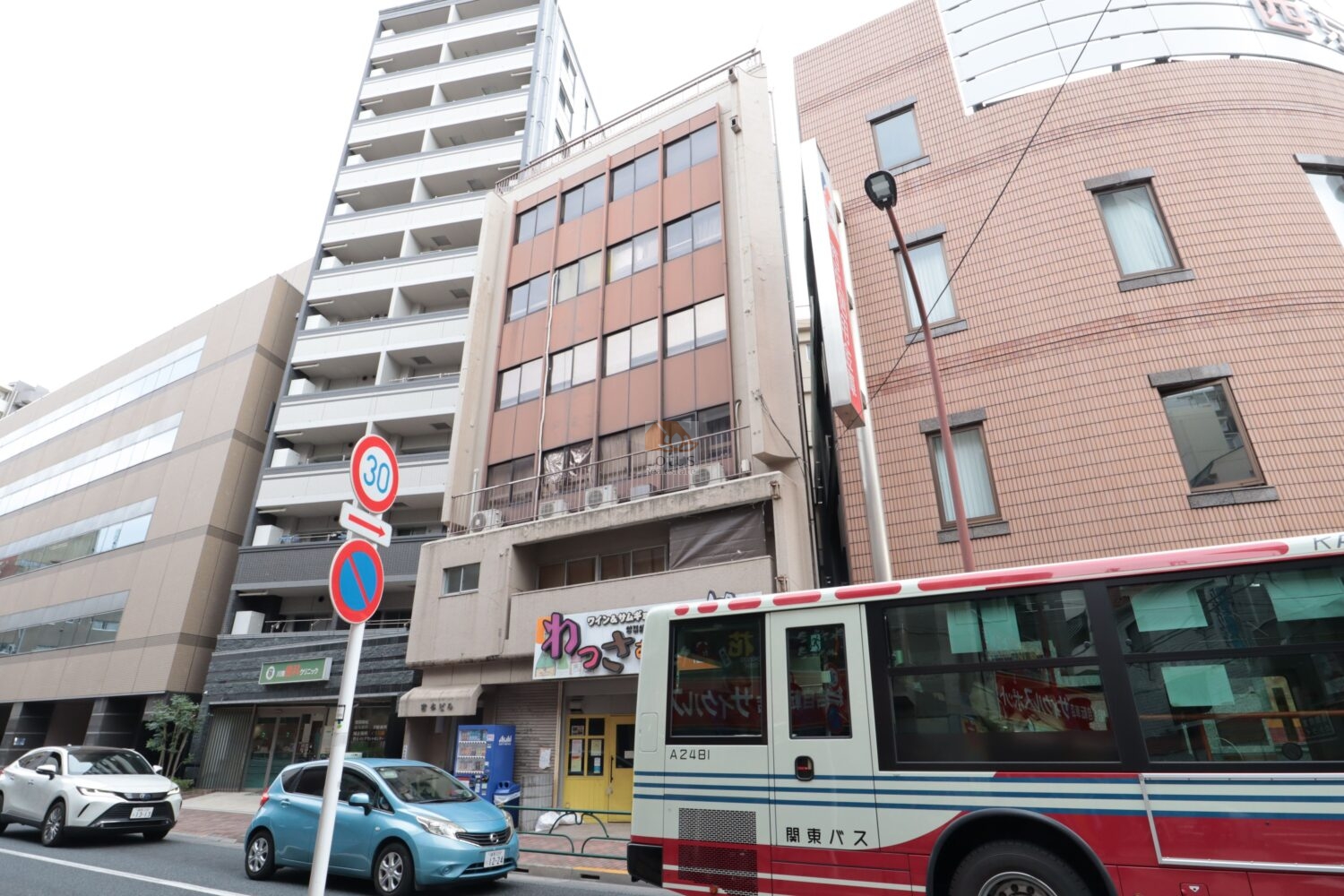 宮本ビルの外観写真です。目白通りから一本入った北町豊玉線に沿いにあります。昔ながらのビルが静かに並んでいる様子が見えてきます。歩道に寄り添うように店が入り、バスや車が行き交う環境で、駅近らしい生活動線の使いやすさがそのまま感じられる立地です。