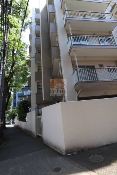 ドミール烏山外観3｜ドミール烏山の外観。縦長の建物は甲州街道に面していて、周囲には自販機や自転車も設置されています。生活利便性のある立地で、実用的な住環境が整っています。
