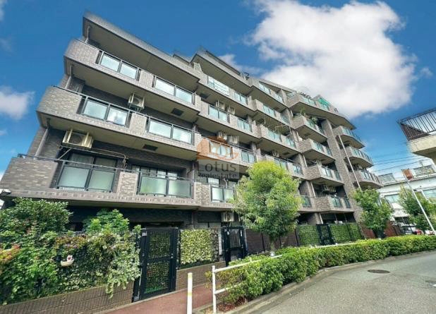 レーベンハイム常盤台ノーヴェは地上6階建の中規模マンションで、落ち着いたグレー系の外壁タイルが整然と貼られています。手前には植栽が並び、黒い門扉が複数設けられ、住戸ごとに独立したエントランス動線が感じられます。レーベンハイム常盤台ノーヴェは、平成12年築、6階建てのマンションです。