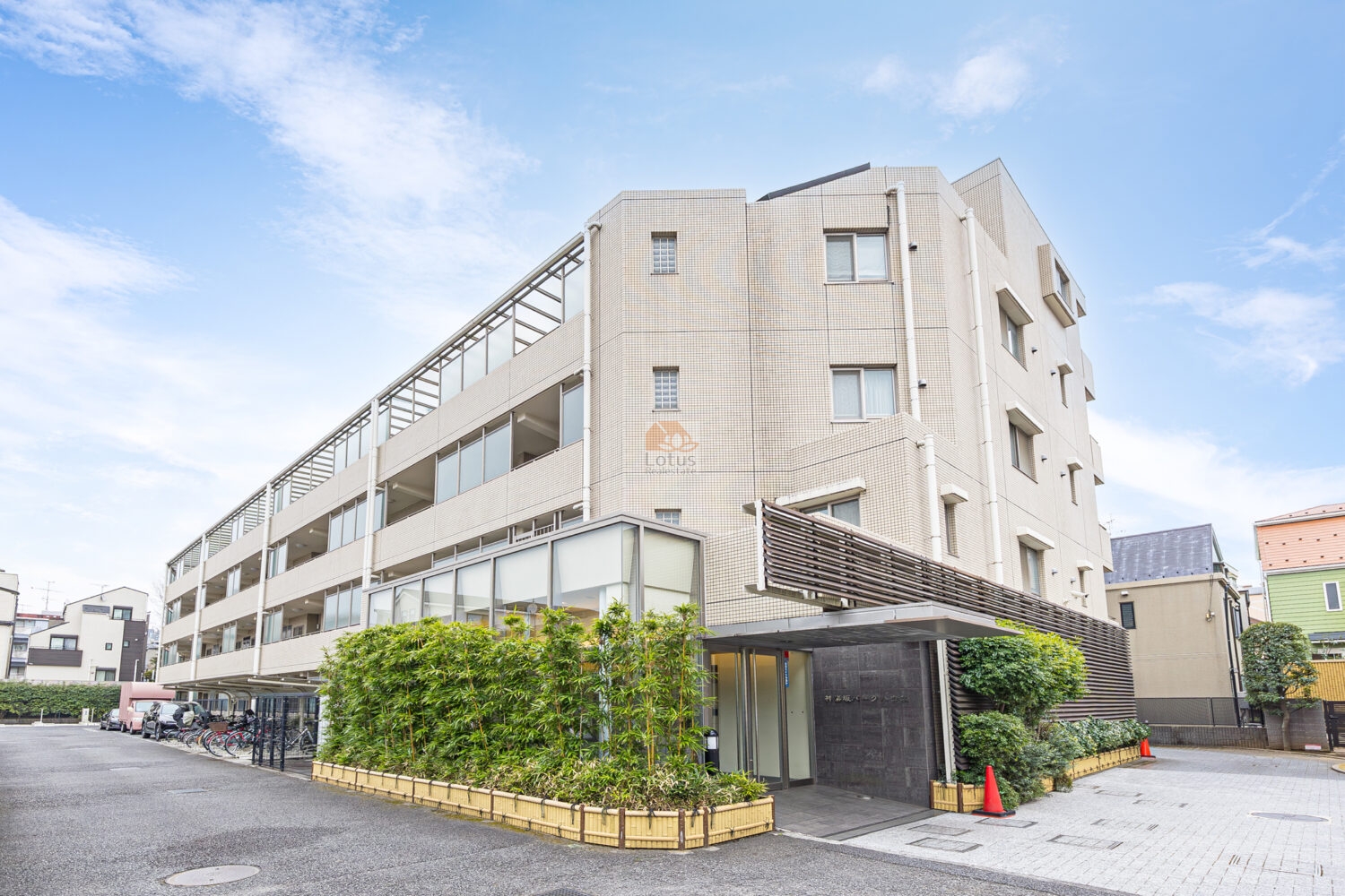 神楽坂パークハウスの外観は、低層5階建て、ベージュ系タイルを基調とした建物が横長に配置されています。ガラス手すり付きのバルコニーと、前面には植栽と駐輪場が確認できます。神楽坂パークハウスは、平成14年築、5階建てのマンションです。