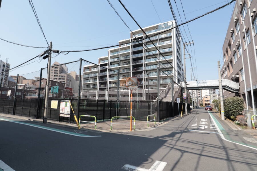 交差点の先にすっと佇む建物は、堂々とした存在感ながらも街に自然と馴染んでいます。歩道橋や学校、通りを行き交う人々…どこか懐かしい、下町らしい風景とともに暮らす毎日が想像できます。