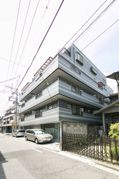 ランドリッツ14｜ランドリッツは、グレートとホワイトを基調とした5階建ての建物で、閑静な住宅街にあります。マンションは角地に立地しており、整然としたデザインでしっかりと管理されています。