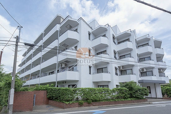白を基調とした外壁のイトーピア上池台マンションは、地上5階建で、通りに面した部分には生け垣とレンガの塀が設けられ、道路からの視線をやわらげています。角地に位置するため、建物全体に光が回りやすく、住戸の窓やバルコニーからは開放感を得られる造りになっています。街並みの中で落ち着いた存在感を保ちながら、日々の生活を快適に支える風景として感じられました。イトーピア上池台マンションは、昭和59年築、5階建てのマンションです。